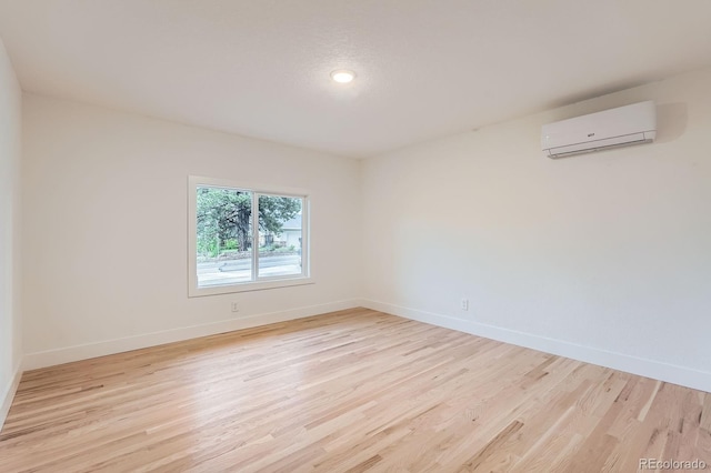10698 W 26th Ave, Lakewood, CO 80215 - empty room featuring a wall mounted air conditioner, light wood-style flooring, and baseboards