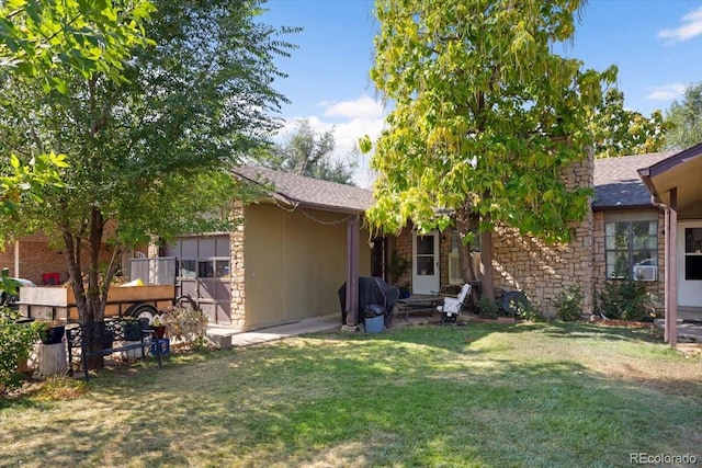 rear view of house featuring a lawn