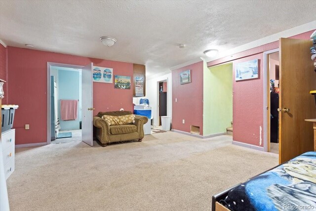 bedroom featuring light colored carpet, a textured ceiling, and connected bathroom