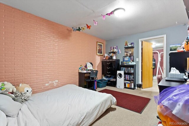 bedroom featuring brick wall and carpet flooring