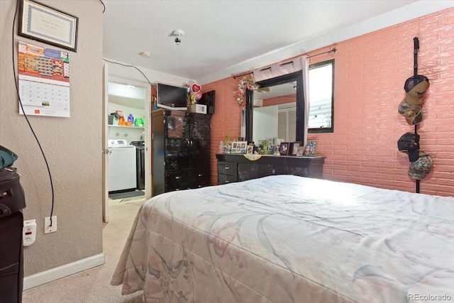 carpeted bedroom with washing machine and clothes dryer and brick wall