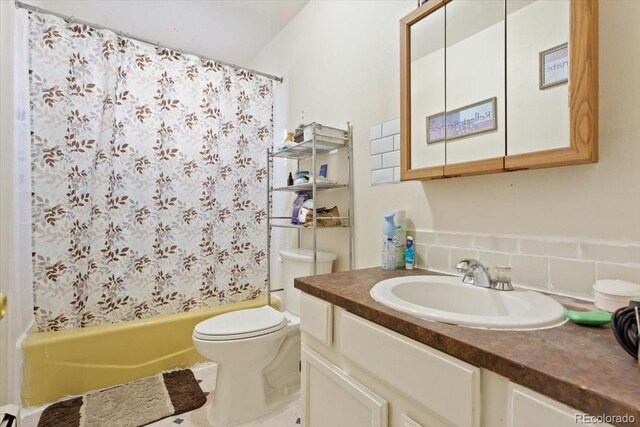 full bathroom featuring shower / bath combination with curtain, backsplash, vanity, and toilet