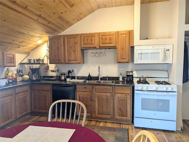 kitchen featuring white appliances, dark countertops, wood finished floors, vaulted ceiling, and a sink