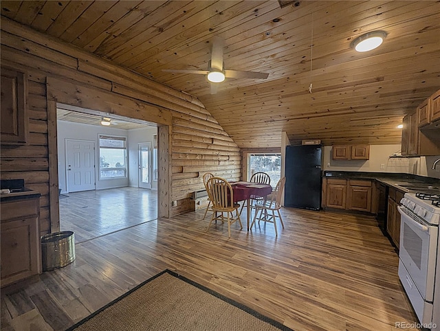kitchen with gas range gas stove, wooden ceiling, dark countertops, ceiling fan, and freestanding refrigerator