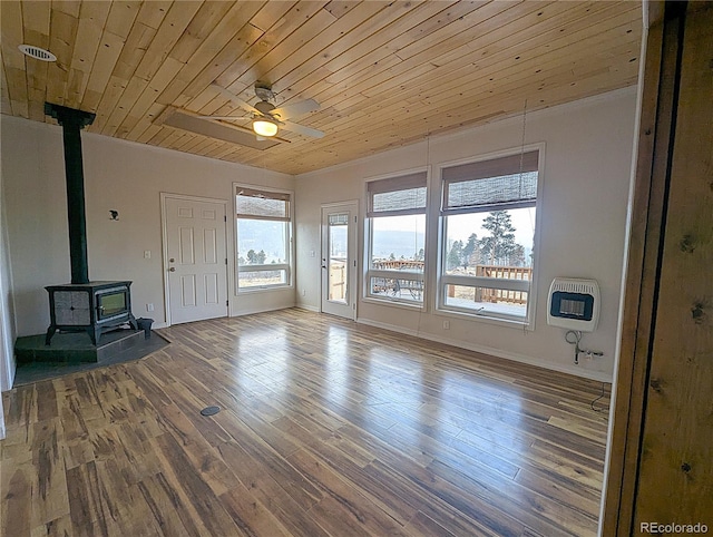 unfurnished living room with wood finished floors, a ceiling fan, heating unit, a wood stove, and wooden ceiling