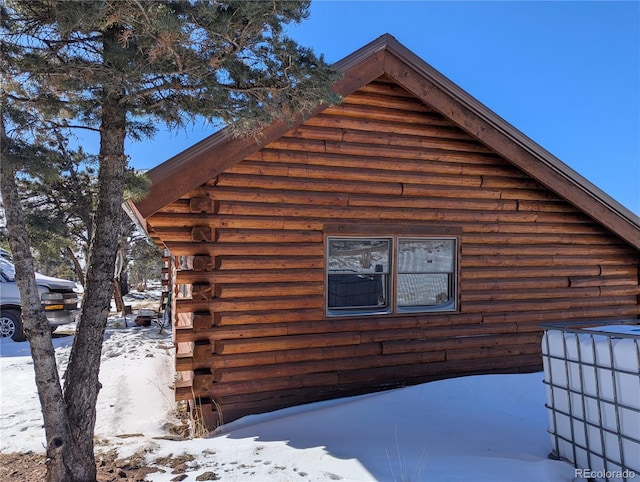 view of snow covered exterior featuring log siding