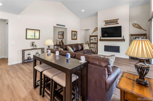 4121 River Oaks St, Castle Rock, CO 80104 - living area featuring light wood-style flooring, high vaulted ceiling, a glass covered fireplace, and recessed lighting