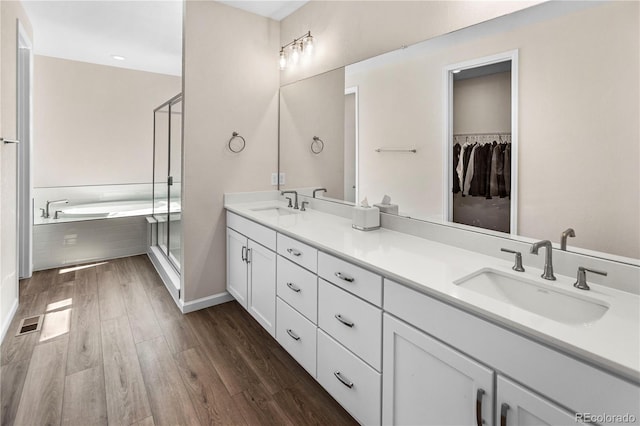 4121 River Oaks St, Castle Rock, CO 80104 - full bath featuring double vanity, a garden tub, wood finished floors, a shower stall, and a walk in closet