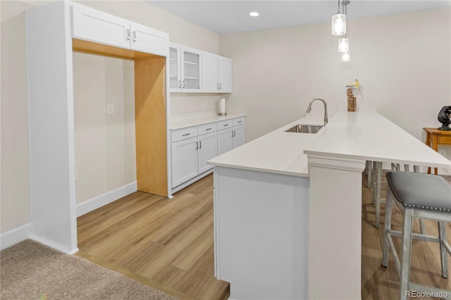4121 River Oaks St, Castle Rock, CO 80104 - kitchen featuring a kitchen bar, a peninsula, white cabinets, glass insert cabinets, and recessed lighting