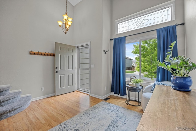 11188 Latigo Ln, Parker, CO 80138 - entryway with a chandelier, a high ceiling, baseboards, wood finished floors, and stairway