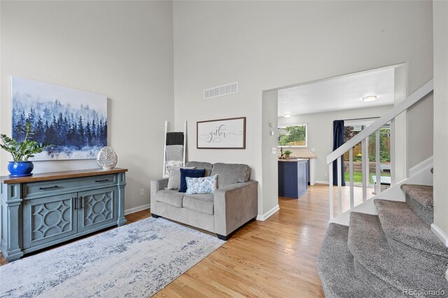 11188 Latigo Ln, Parker, CO 80138 - living room featuring wood finished floors, stairs, a towering ceiling, and baseboards