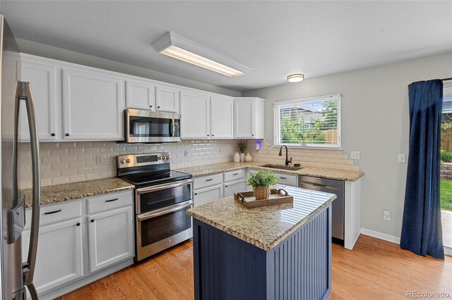 11188 Latigo Ln, Parker, CO 80138 - kitchen featuring appliances with stainless steel finishes, a sink, light wood finished floors, and backsplash