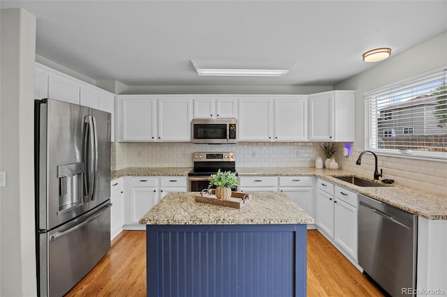11188 Latigo Ln, Parker, CO 80138 - kitchen with appliances with stainless steel finishes, a sink, a kitchen island, and white cabinets