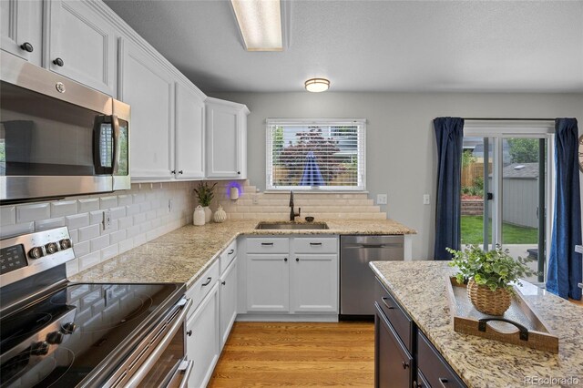 11188 Latigo Ln, Parker, CO 80138 - kitchen featuring appliances with stainless steel finishes, a sink, white cabinetry, and backsplash