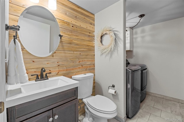 11188 Latigo Ln, Parker, CO 80138 - half bath featuring washing machine and clothes dryer, wooden walls, toilet, vanity, and baseboards