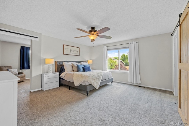 11188 Latigo Ln, Parker, CO 80138 - carpeted bedroom featuring a barn door, a textured ceiling, a ceiling fan, and baseboards