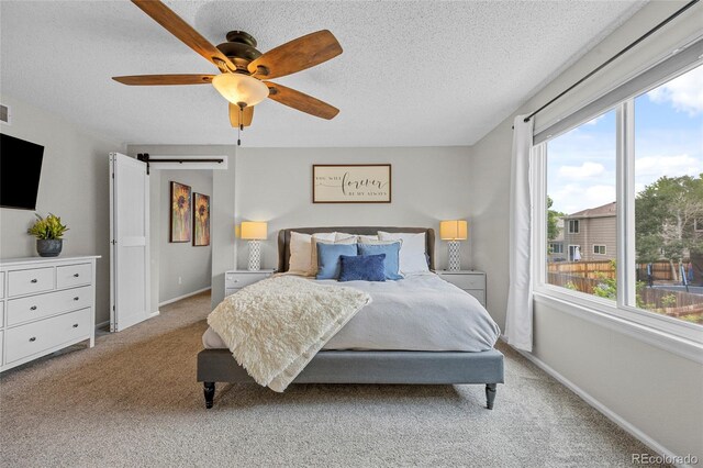 11188 Latigo Ln, Parker, CO 80138 - bedroom with light carpet, a barn door, a textured ceiling, baseboards, and ceiling fan