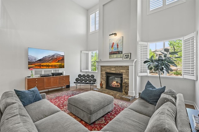 2090 Bellavista St, Castle Rock, CO 80109 - living room with a towering ceiling, a brick fireplace, wood finished floors, and baseboards
