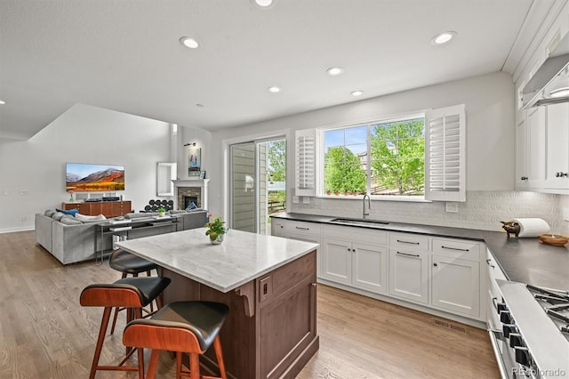 2090 Bellavista St, Castle Rock, CO 80109 - kitchen with a sink, cooktop, a breakfast bar area, white cabinetry, and recessed lighting