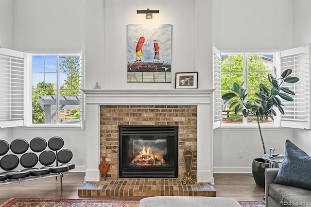 2090 Bellavista St, Castle Rock, CO 80109 - sitting room featuring wood finished floors, a fireplace, baseboards, and a towering ceiling