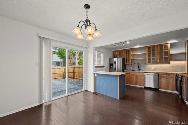 11651 Pennsylvania St, Northglenn, CO 80233 - kitchen featuring stainless steel appliances, a chandelier, brown cabinets, a textured ceiling, and backsplash