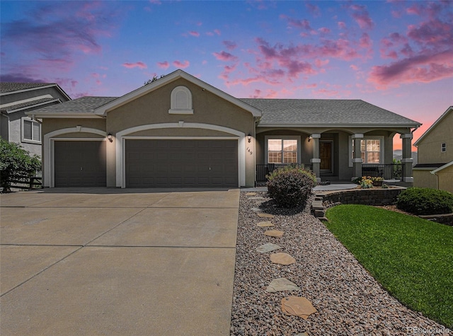 149 Walters Creek Dr, Monument, CO 80132 - single story home featuring an attached garage, driveway, stucco siding, covered porch, and roof with shingles
