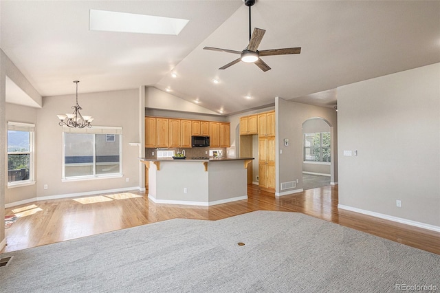149 Walters Creek Dr, Monument, CO 80132 - kitchen with black microwave, open floor plan, light wood-style flooring, a ceiling fan, and lofted ceiling