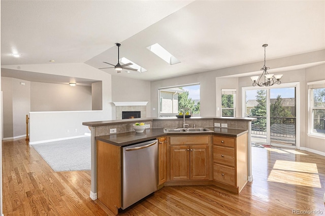 149 Walters Creek Dr, Monument, CO 80132 - kitchen with stainless steel dishwasher, open floor plan, light wood-style flooring, dark countertops, and vaulted ceiling