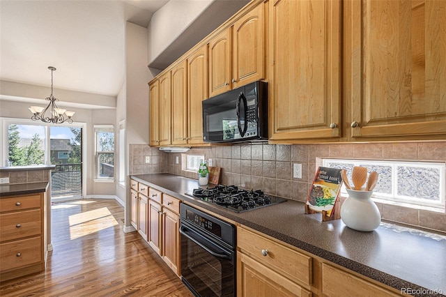 149 Walters Creek Dr, Monument, CO 80132 - kitchen with black appliances, dark countertops, decorative backsplash, light wood-style flooring, and light brown cabinets