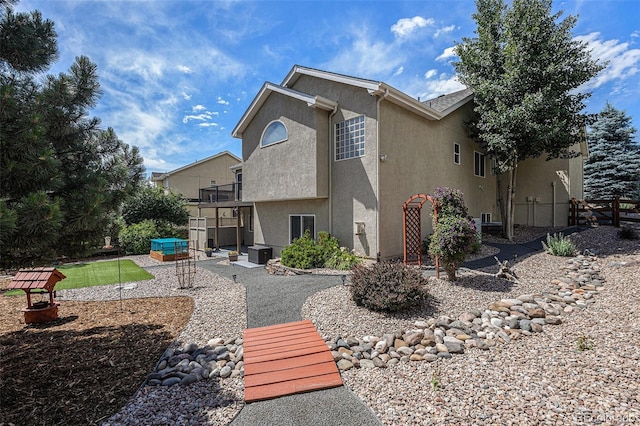 149 Walters Creek Dr, Monument, CO 80132 - rear view of house with stucco siding, a hot tub, and a patio