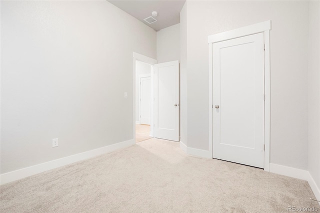 unfurnished bedroom with a closet and light carpet