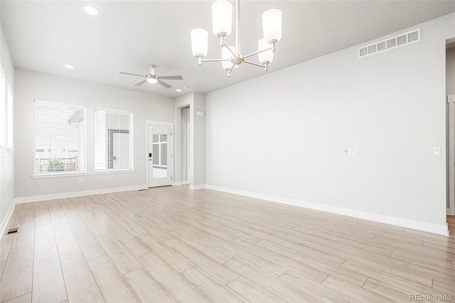 unfurnished room with ceiling fan with notable chandelier and light wood-type flooring