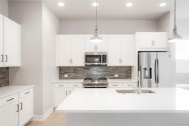 kitchen with appliances with stainless steel finishes, hanging light fixtures, white cabinets, and tasteful backsplash