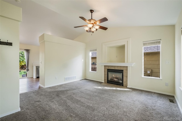 unfurnished living room featuring ceiling fan, carpet flooring, vaulted ceiling, and a fireplace