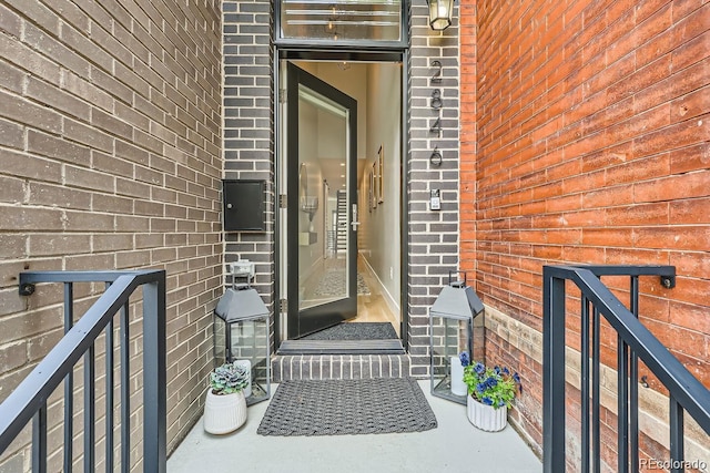 view of exterior entry featuring brick siding