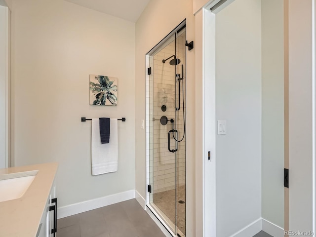 full bath with a stall shower, vanity, and baseboards