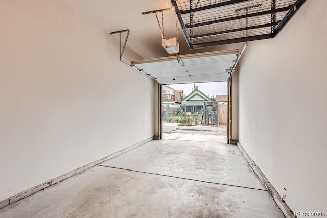 garage with baseboards and a garage door opener