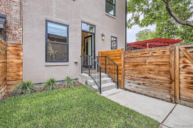 property entrance featuring fence and stucco siding