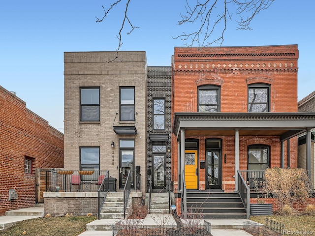 view of front of home featuring covered porch and brick siding