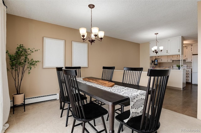 dining area featuring a notable chandelier, a textured ceiling, and a baseboard heating unit