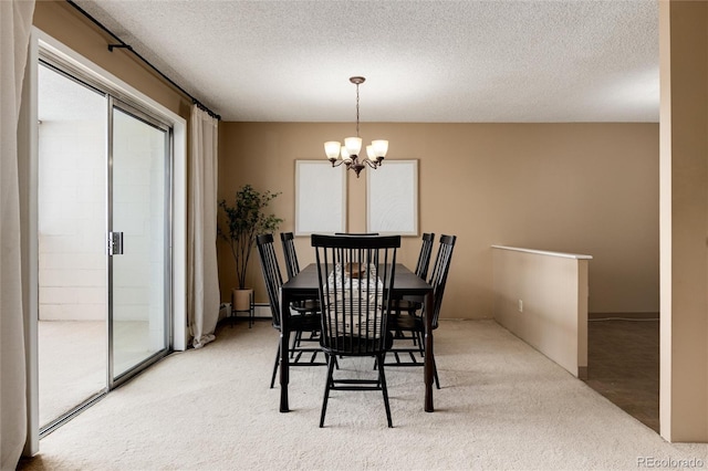 dining area featuring carpet flooring, a chandelier, and a textured ceiling