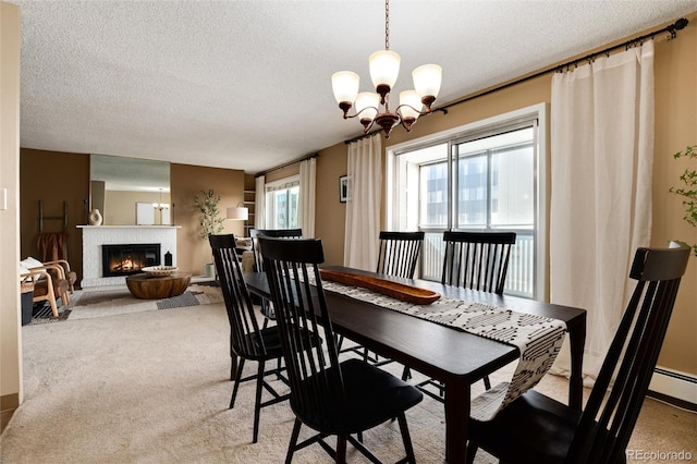 carpeted dining room featuring a textured ceiling, a fireplace, and an inviting chandelier