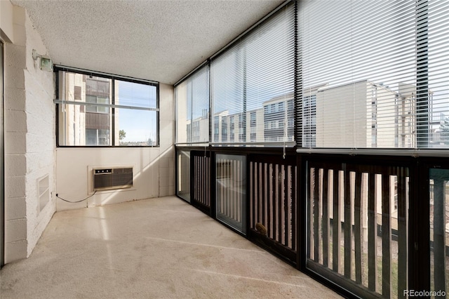 unfurnished sunroom featuring a wall unit AC