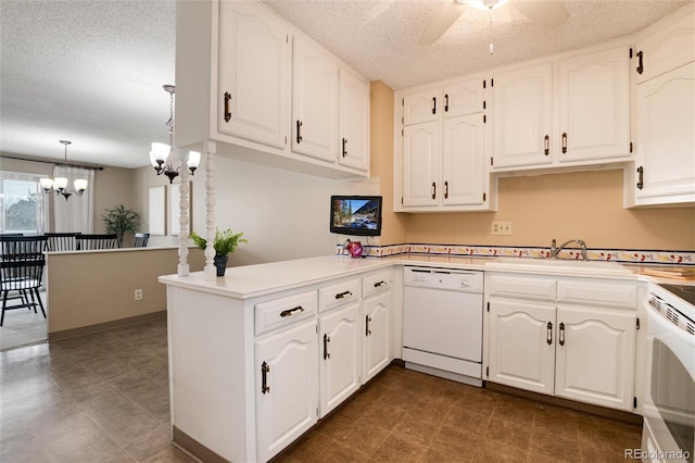 kitchen with white dishwasher, sink, kitchen peninsula, hanging light fixtures, and white cabinetry