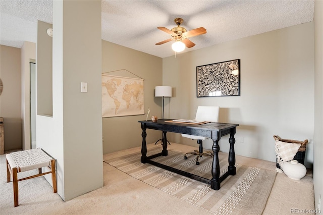 carpeted office with a textured ceiling and ceiling fan