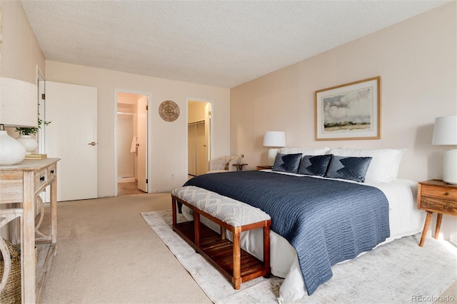 carpeted bedroom featuring a spacious closet, a textured ceiling, and a closet