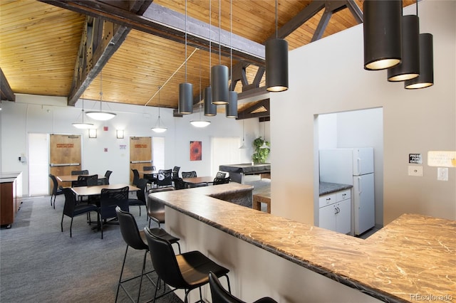 kitchen with wooden ceiling, high vaulted ceiling, hanging light fixtures, beamed ceiling, and white fridge