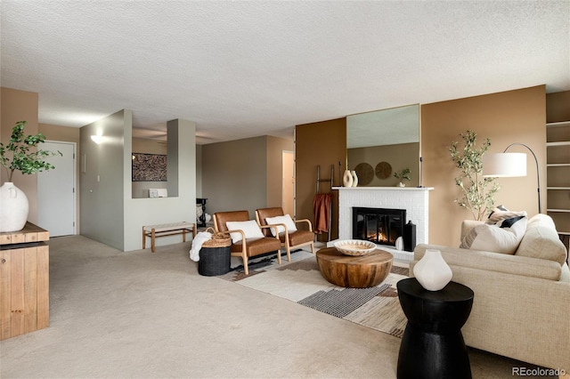 carpeted living room with a fireplace and a textured ceiling