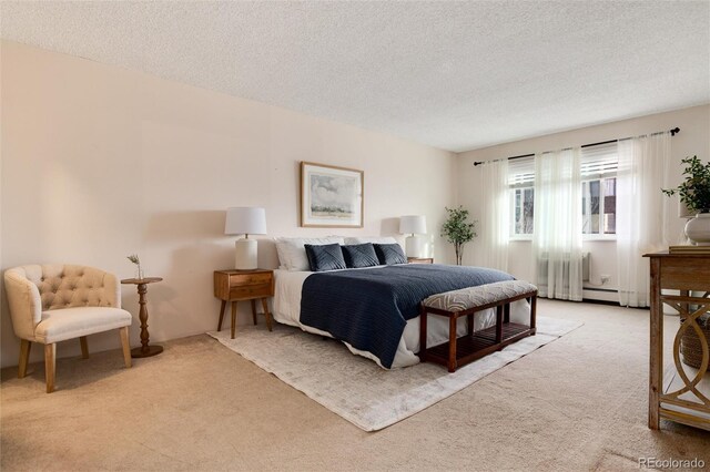 carpeted bedroom with a textured ceiling and a baseboard heating unit