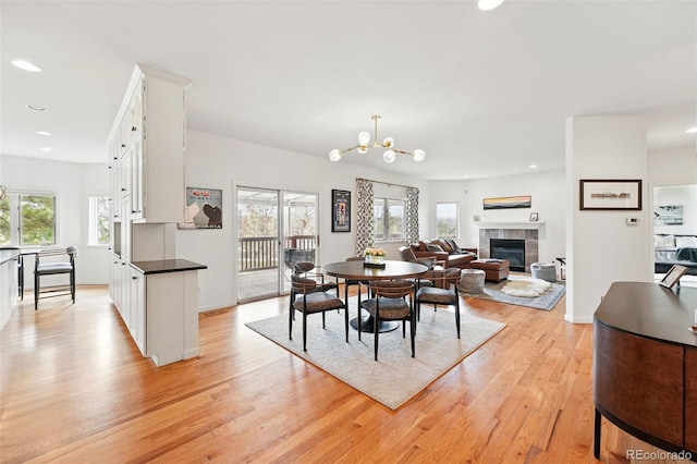 4212 E Orchard Pl, Centennial, CO 80121 - dining space with light wood finished floors, a tile fireplace, recessed lighting, a chandelier, and baseboards